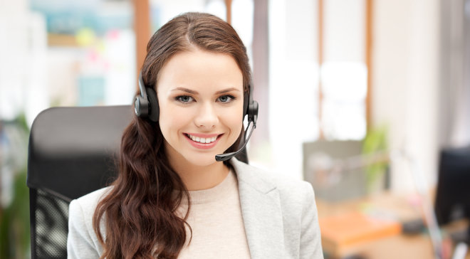 Smiling young woman in call center wearing a headset